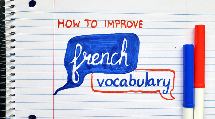 The words "how to improve French vocabulary" on a notebook with markers